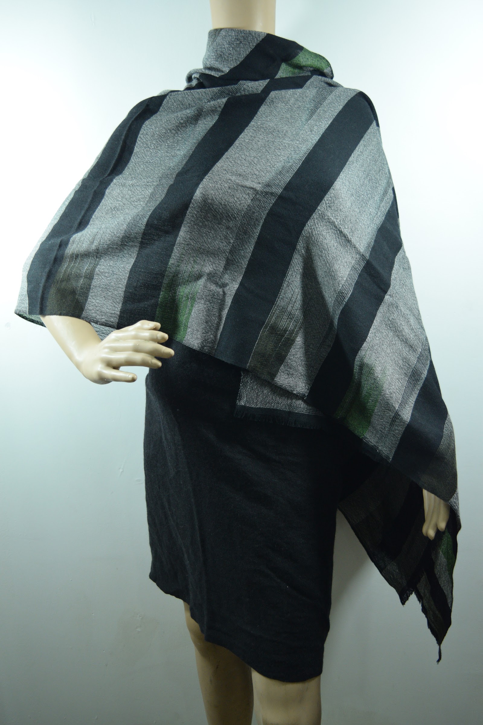 Grey and black striped woven cashmere wrap draped on a mannequin